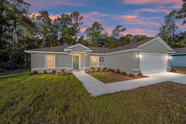 single story home featuring a garage, driveway, a front lawn, and stucco siding