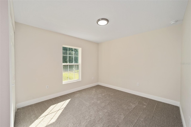 carpeted spare room with baseboards