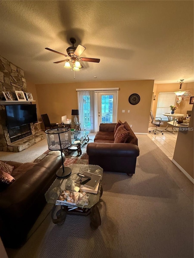 carpeted living area with ceiling fan and a textured ceiling