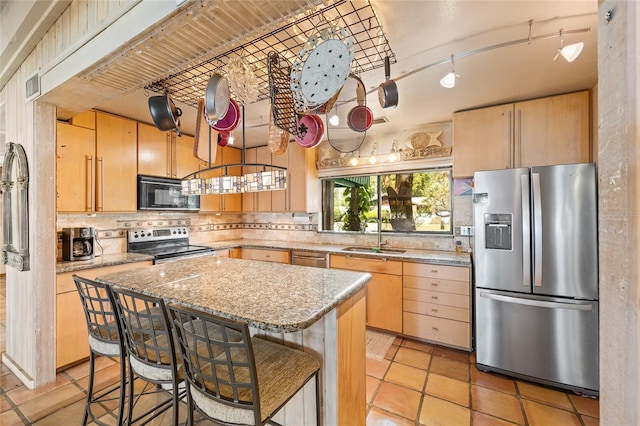 31 SE Chinica Dr, Summerfield, FL 34491 - kitchen featuring appliances with stainless steel finishes, light brown cabinets, decorative backsplash, a center island, and a breakfast bar area