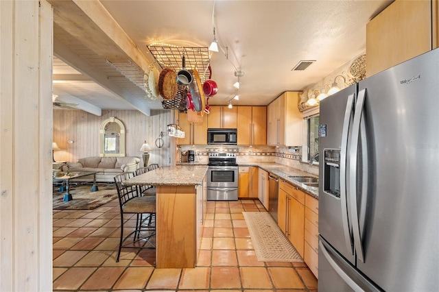 31 SE Chinica Dr, Summerfield, FL 34491 - kitchen featuring stainless steel appliances, light brown cabinetry, open floor plan, a breakfast bar area, and a kitchen island