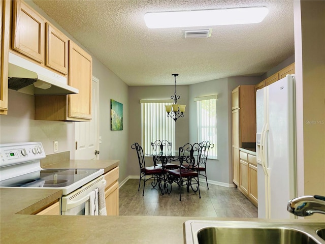 kitchen with a textured ceiling, a sink, light wood-style floors, under cabinet range hood, and white appliances