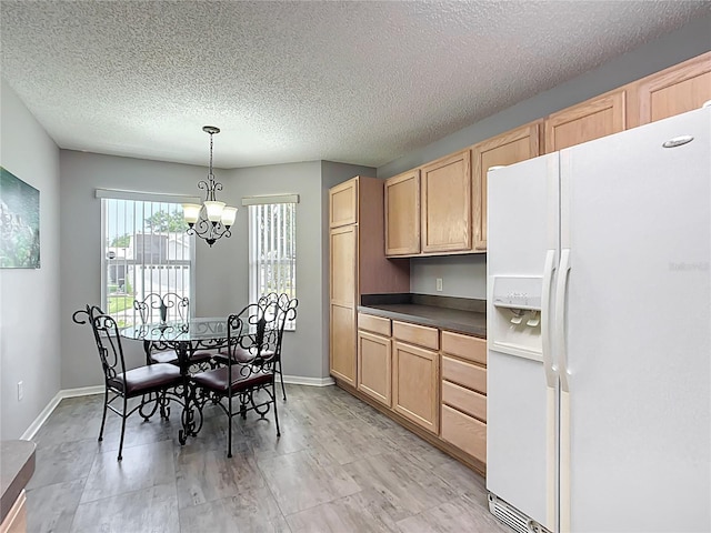 kitchen with light brown cabinetry, dark countertops, a textured ceiling, a notable chandelier, and white fridge with ice dispenser