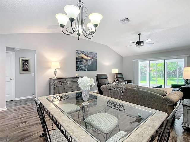 dining space with visible vents, vaulted ceiling, dark wood finished floors, baseboards, and ceiling fan with notable chandelier