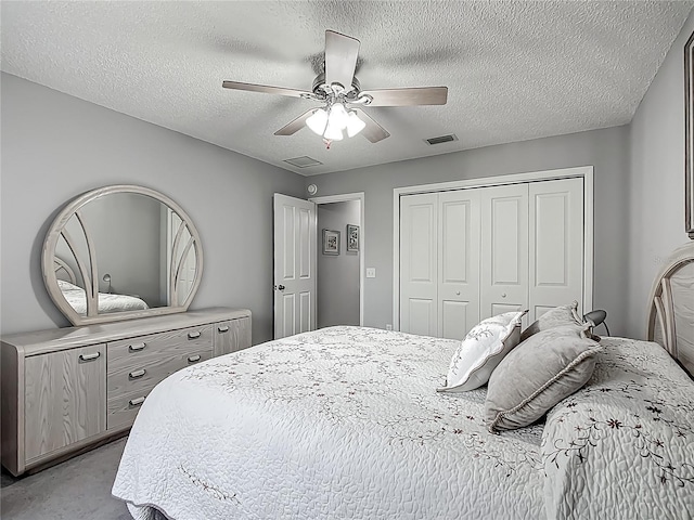 bedroom featuring ceiling fan, a closet, a textured ceiling, and visible vents