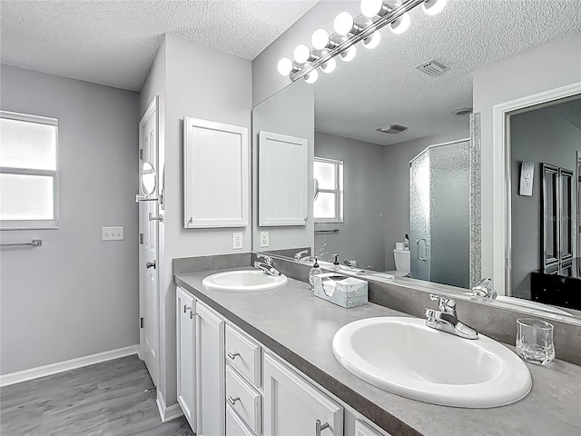 bathroom featuring a textured ceiling, a wealth of natural light, and a sink