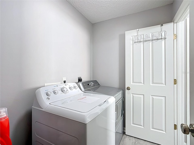 laundry area with laundry area, a textured ceiling, and independent washer and dryer