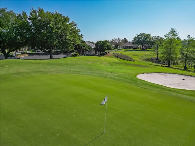 view of property's community featuring a yard and view of golf course
