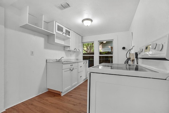 935 NE Sanchez Ave, Ocala, FL 34470 - kitchen with white cabinets, open shelves, visible vents, and light wood-style flooring