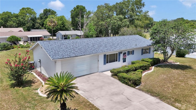 11118 SW 76th Ave, Ocala, FL 34476 - ranch-style house with a shingled roof, an attached garage, a front yard, concrete driveway, and view of scattered trees