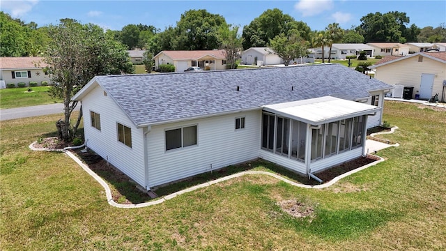 11118 SW 76th Ave, Ocala, FL 34476 - back of house with roof with shingles, a sunroom, a lawn, and a residential view