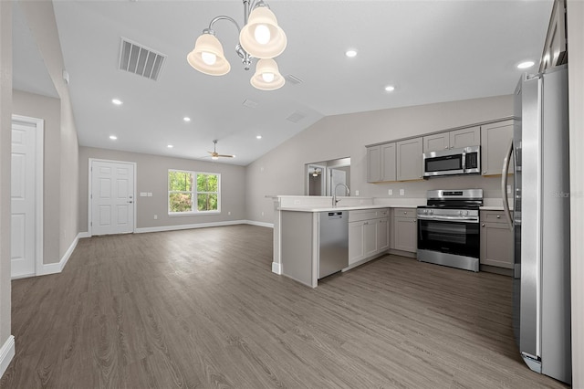 10435 SE 125th Ln, Belleview, FL 34420 - kitchen featuring lofted ceiling, gray cabinetry, visible vents, open floor plan, and appliances with stainless steel finishes