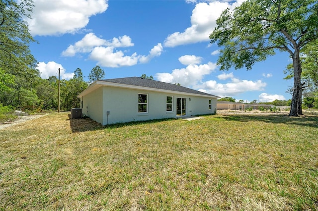 10435 SE 125th Ln, Belleview, FL 34420 - back of property featuring central air condition unit, stucco siding, and a lawn