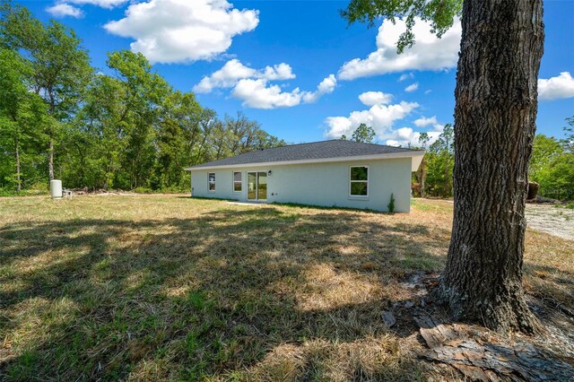 10435 SE 125th Ln, Belleview, FL 34420 - back of property with stucco siding and a lawn