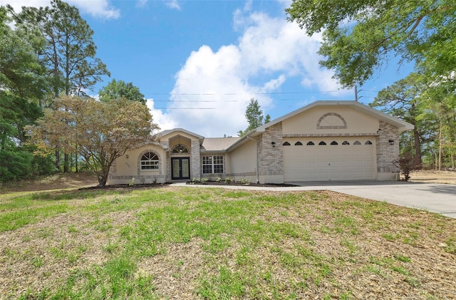 ranch-style house with a front yard, an attached garage, stucco siding, french doors, and driveway