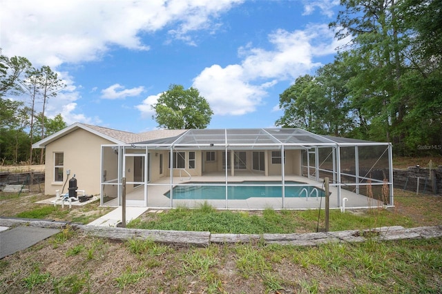 back of house with an outdoor pool, glass enclosure, a patio, and stucco siding
