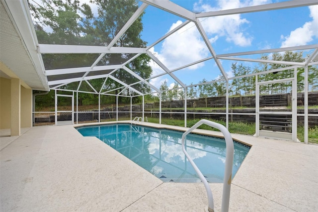 view of swimming pool with fence, a fenced in pool, a patio, and glass enclosure