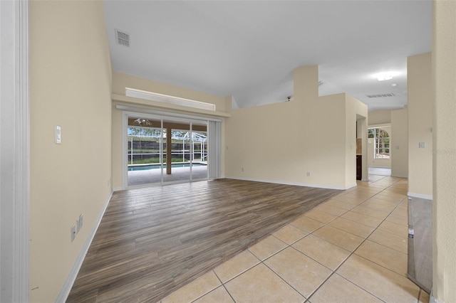 empty room with light wood-type flooring, visible vents, and plenty of natural light