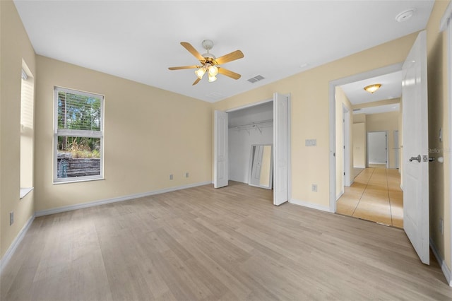 unfurnished bedroom featuring a closet, light wood-type flooring, baseboards, visible vents, and ceiling fan