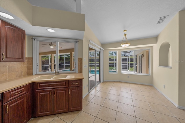 kitchen with light tile patterned floors, light countertops, a ceiling fan, visible vents, and a sink