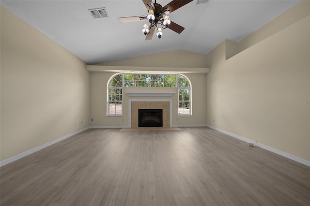 unfurnished living room featuring a tile fireplace, visible vents, a ceiling fan, and wood finished floors