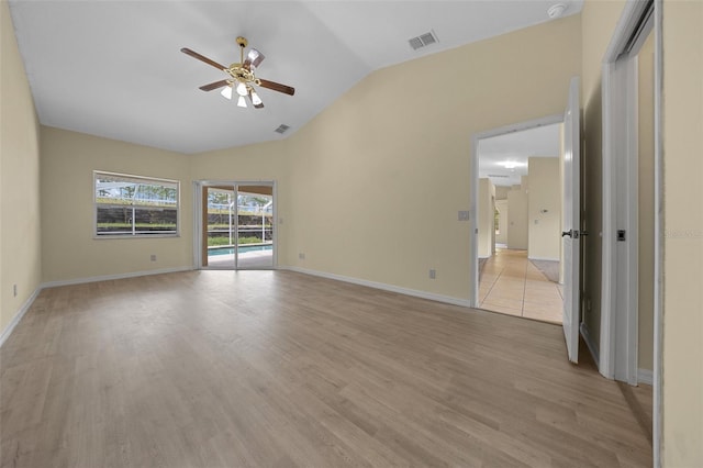 empty room with light wood finished floors, lofted ceiling, visible vents, and ceiling fan