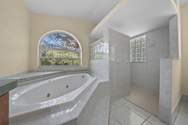 bathroom with tile patterned floors, a jetted tub, and tiled shower