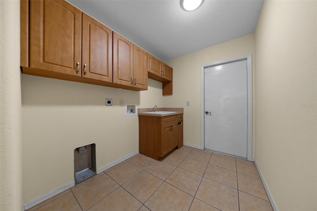 clothes washing area with light tile patterned floors, hookup for an electric dryer, washer hookup, baseboards, and cabinet space