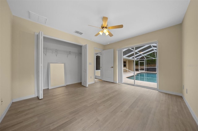 unfurnished bedroom featuring visible vents, baseboards, a closet, wood finished floors, and access to outside