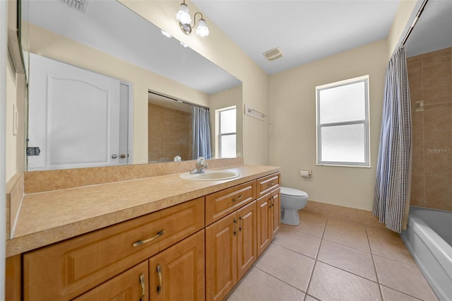 bathroom featuring vanity, toilet, tile patterned flooring, and a healthy amount of sunlight