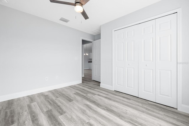 unfurnished bedroom featuring baseboards, ceiling fan, a closet, and light wood-type flooring