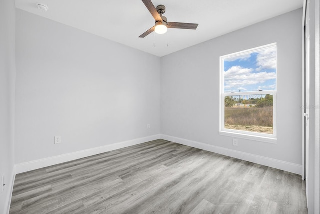 empty room featuring a ceiling fan, wood finished floors, and baseboards
