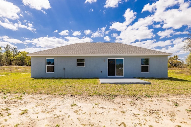 back of property featuring a yard, stucco siding, and a patio