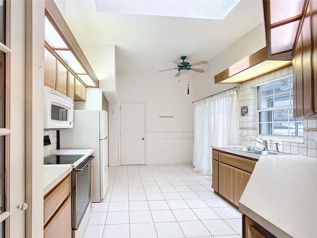 kitchen with range with electric cooktop, a sink, light countertops, a ceiling fan, and white microwave