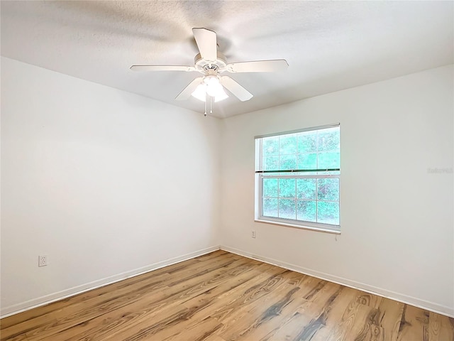 unfurnished room featuring light wood finished floors, baseboards, and a ceiling fan