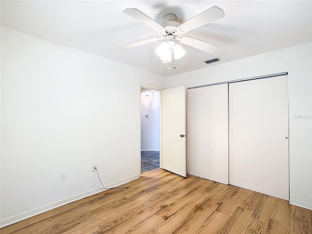 unfurnished bedroom with visible vents, ceiling fan, light wood-type flooring, and a closet