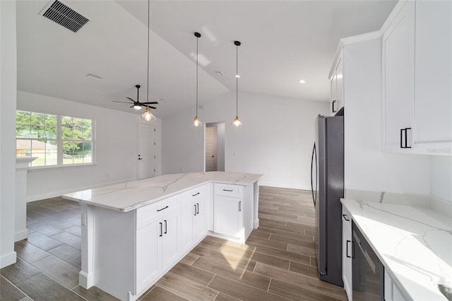 kitchen with appliances with stainless steel finishes, lofted ceiling, wood finish floors, a center island, and white cabinets