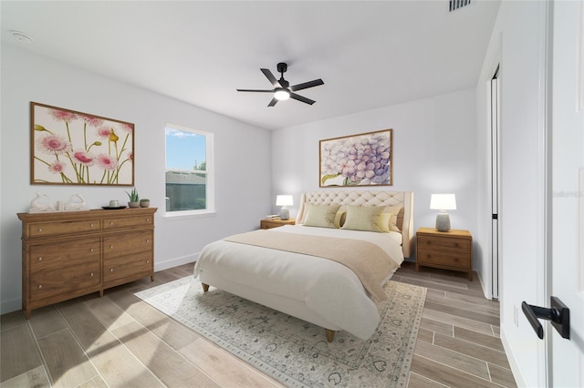 bedroom featuring light wood-style floors, baseboards, and a ceiling fan