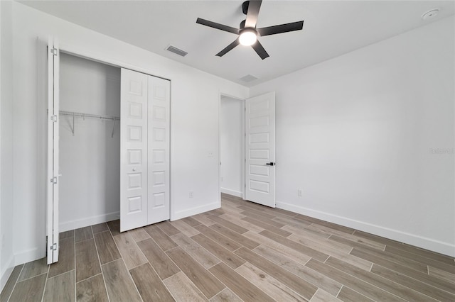 unfurnished bedroom with wood finished floors, a closet, baseboards, and ceiling fan
