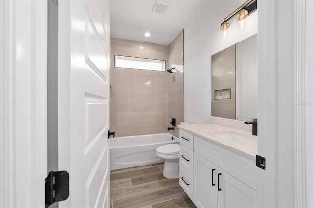 bathroom featuring toilet, vanity, shower / bath combination, and wood finished floors