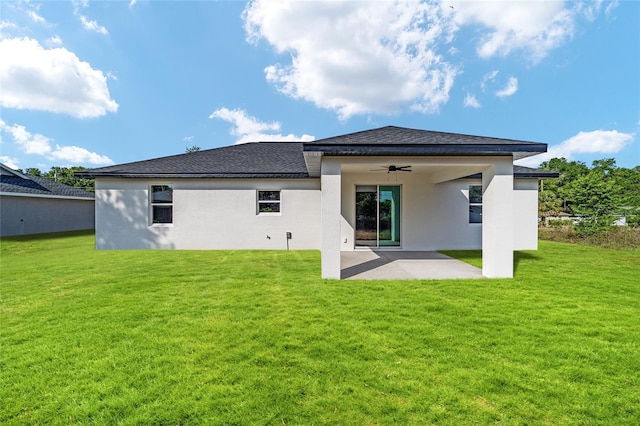 back of property featuring a ceiling fan, a patio, a lawn, and stucco siding