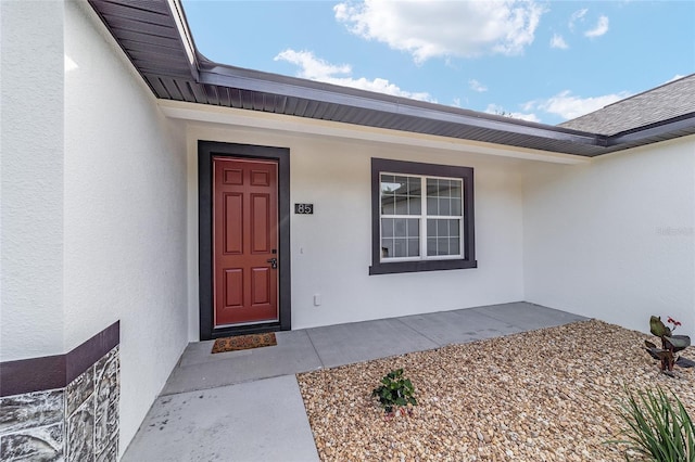 view of exterior entry with stucco siding