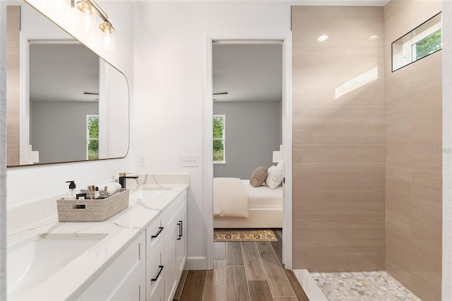 full bathroom featuring wood finished floors, connected bathroom, and double vanity
