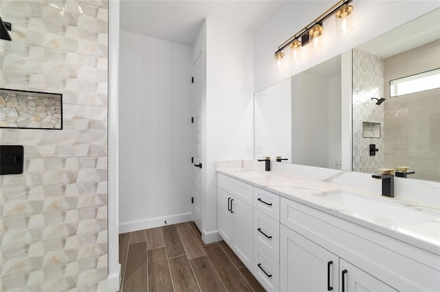 bathroom with walk in shower, wood finished floors, double vanity, baseboards, and toilet