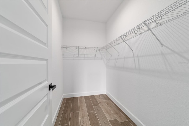 walk in closet featuring dark wood finished floors