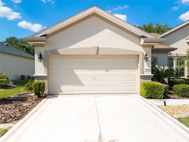 ranch-style house with an attached garage, driveway, and stucco siding
