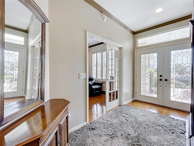 entrance foyer with crown molding, french doors, a textured wall, and wood finished floors