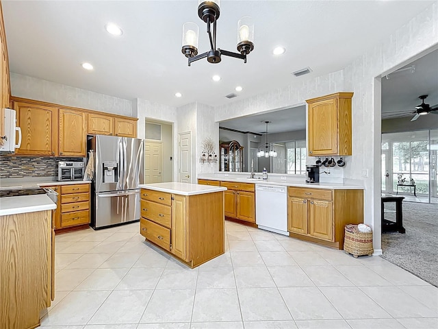 kitchen with white appliances, visible vents, light countertops, and a kitchen island