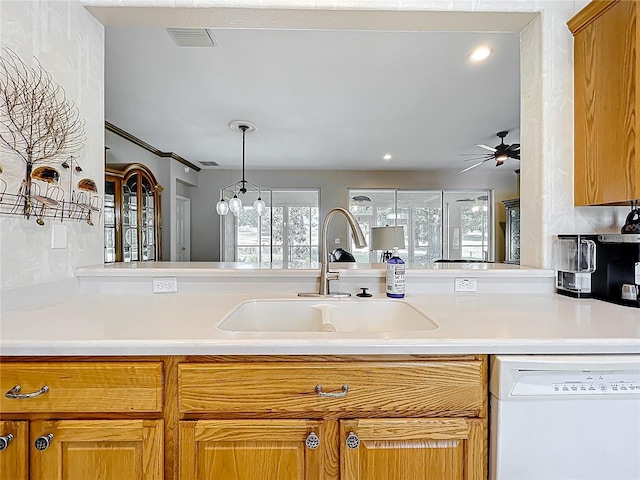 kitchen with recessed lighting, light countertops, white dishwasher, ceiling fan with notable chandelier, and a sink