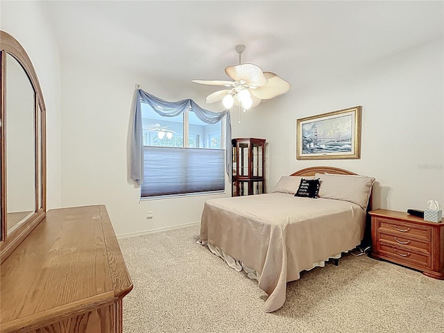 bedroom featuring light colored carpet and a ceiling fan